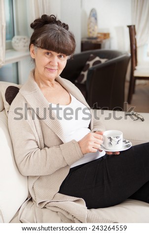 Pension age good looking woman with cup of tea