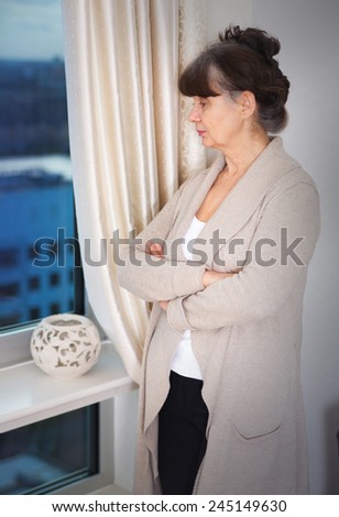 Pension age good looking woman looking in window