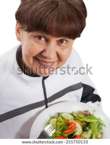 Pension age woman in sport costume with salad. Healthy life style concept