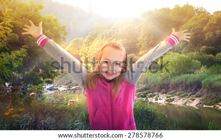 Sunrise, beautiful park and happy girl raising her hands up to the sun. Happy and healthy life concept