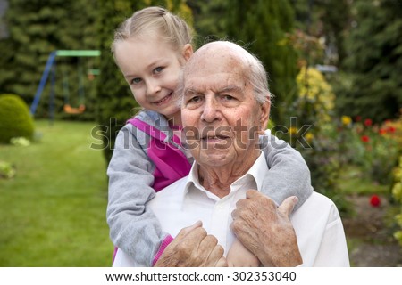 95 years old english man with granddaughter in garden