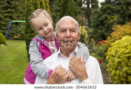 95 years old english man with granddaughter in garden