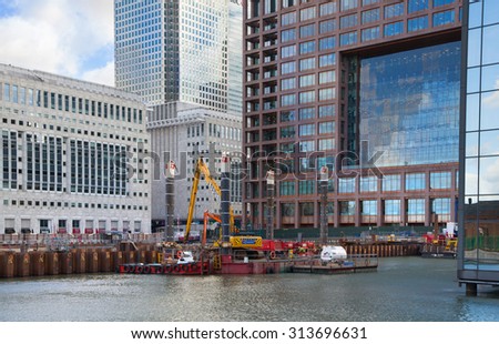 LONDON, UK - MARCH 31, 2015: Canary Wharf building site with cranes and digger. New resident skyscraper going to be raised next to Canary Wharf business development