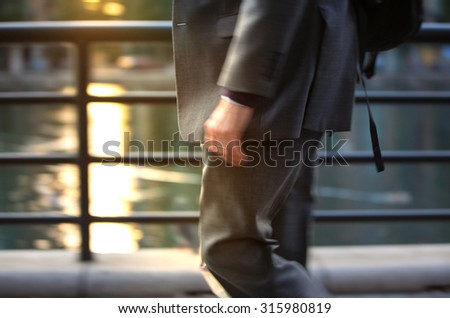Business man in suit walking against of sunset light, London