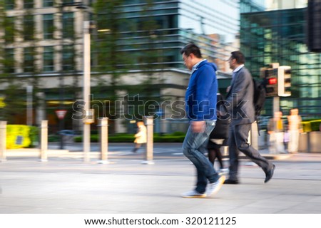 LONDON, UK - MAY 21, 2015:  Blur of Business people walking on street after working day. Canary Wharf