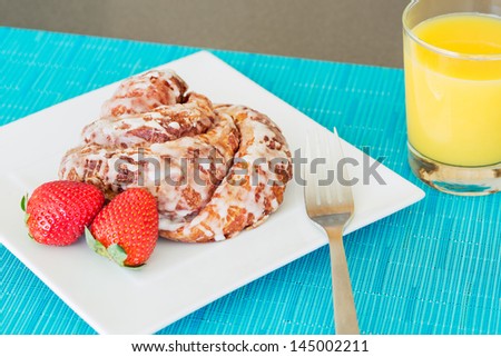 Delicious Cinnamon Roll Sticky Bun with Strawberries and Orange Juice