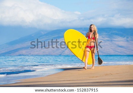 Attractive Woman with Stand Up Paddle Board, SUP, on the beach in Hawaii