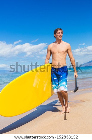 Man with Stand Up Paddle Board, SUP, on the beach in Hawaii