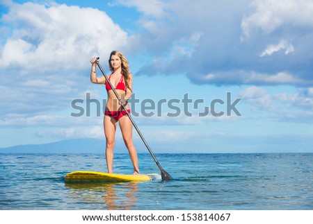 Young Attractive Woman on Stand Up Paddle Board, SUP, in the Blue Waters off Hawaii, Active Life Concept