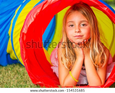 Cute Young Girl Playing Outside in Colorful Tunnel