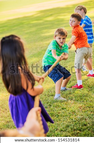 Group of Kids Playing Tug of War On Grass