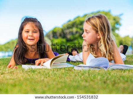 Cute Little Girls Reading Books Outside on Grass after School