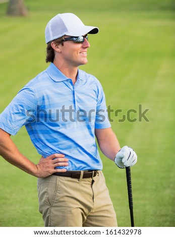 Athletic young man playing golf, Portrait of Golfer on Course