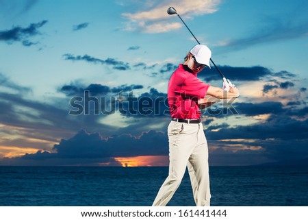 Golfer at sunset, Man swinging golf club with dramatic sunset sky backdrop