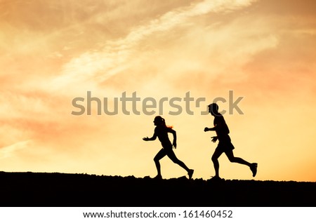 Silhouette of Man and woman running together into sunset, Wellness fitness concept