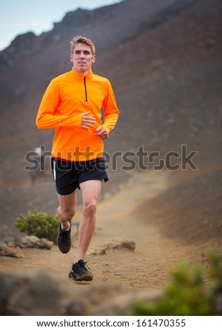 Athletic man jogging outside, training outdoors. Running on nature trail