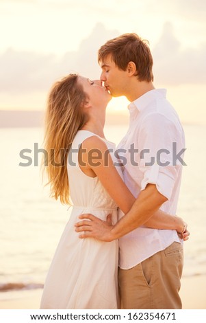 Happy romantic couple kissing on the beach at sunset, Man and woman in love