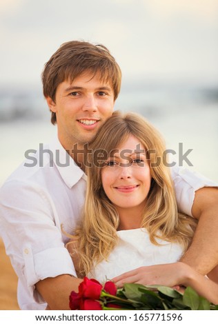 Young couple in love, Attractive man and woman enjoying romantic date at the beach at sunset