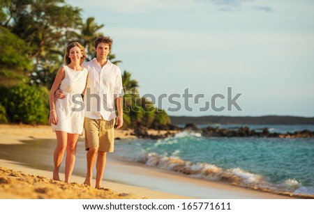 Young couple in love, Attractive man and woman enjoying romantic evening walk on the beach,  Watching the sunset