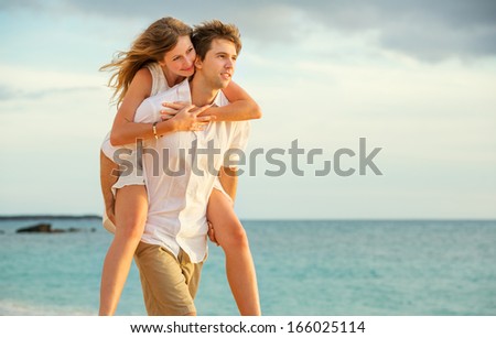 Young couple in love, Attractive man and woman enjoying romantic evening walk on the beach,  Watching the sunset