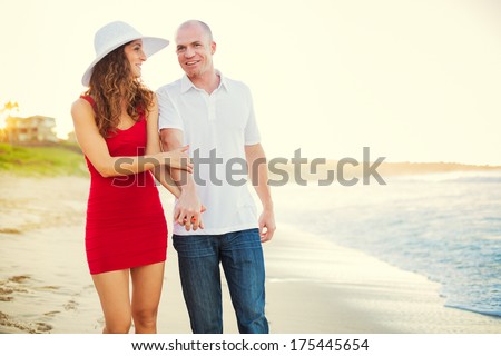 Happy couple in love, enjoying sunset walk on the beach