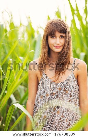 Beautiful young woman outdoors. Romantic Fashion Lifestyle Model in Sun Dress. Happy emotions. Backlit. Warm color tones