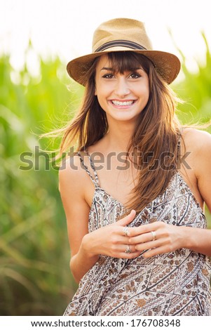 Beautiful young woman outdoors. Romantic Fashion Lifestyle Model in Sun Dress. Happy emotions. Backlit. Warm color tones