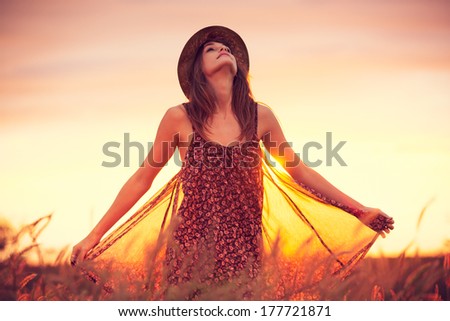 Beautiful woman in golden field at sunset, Fashion lifestyle, Vibrant color, Backlit warm tones