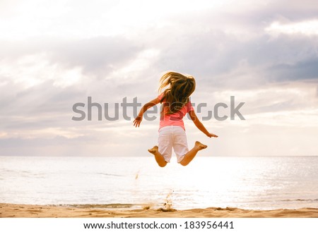 Happy girl jumping on the beach Sunset
