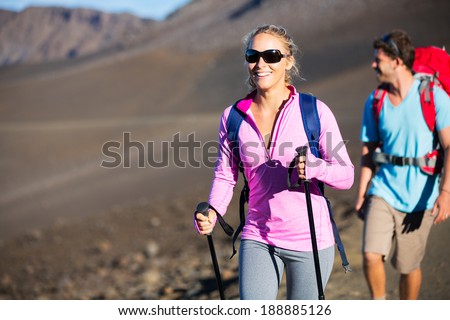 Hiking in the mountains. Happy athletic couple with backpacks enjoying hike outdoors on beautiful mountain trail.