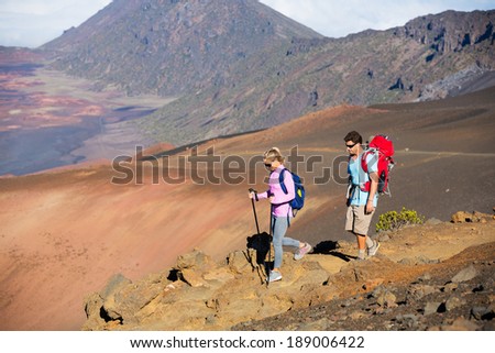 Hiking in the mountains. Athletic couple with backpacks enjoying hike outdoors.