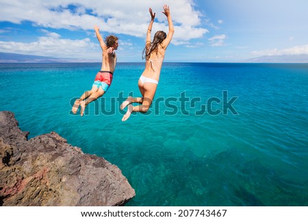 Friends cliff jumping into the ocean, summer fun lifestyle.