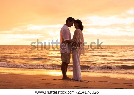 Romantic Middle Aged Couple in Love Embracing on the Beach at Sunset