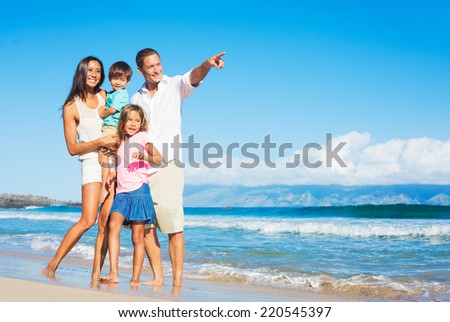 Happy Mixed Race Family of Four Playing on the Beach