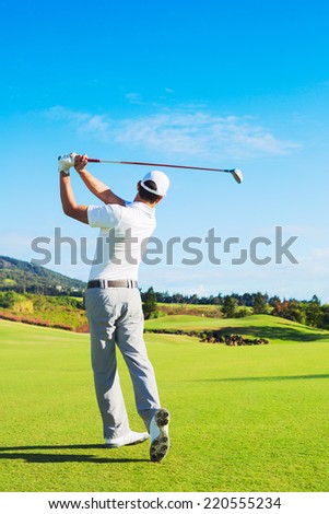 Man Playing Golf on Beautiful Sunny Green Golf Course. Hitting Golf Ball down the Fairway.
