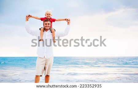 Father and Son Playing on the Beach by the Ocean