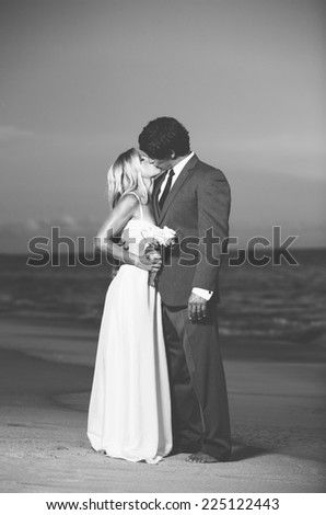 Beautiful Wedding Couple, Bride and Groom Kissing on the Beach at Sunset. Black and White Photograph