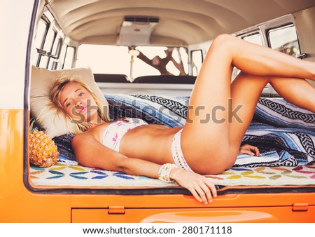 Beach Lifestyle, Beautiful Surfer Girl Relaxing in Classic Vintage Surf Van on the Beach at Sunset