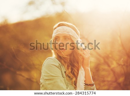 Fashion Lifestyle, Portrait of Beautiful Young Woman Backlit at Sunset Outdoors. Soft warm sunny colors.