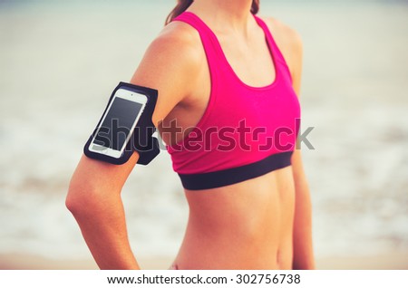 Active Healthy Sports Lifestyle with Modern Technology. Young attractive fitness woman with smart phone ready for workout.
