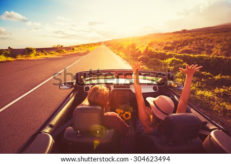 Happy Young Couple Driving Along Country Road in Convertible at Sunset. Freedom Adventure Road Trip