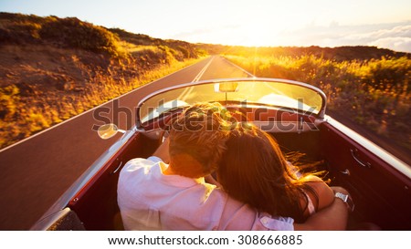 Driving into the Sunset. Romantic Young Couple Enjoying Sunset Drive in Classic Vintage Sports Car