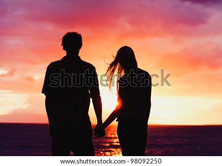 Silhouette of Young Romantic Couple Holding Hands at Sunset