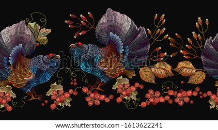 Wood grouse and red branches of a mountain ash berry, horizontal seamless pattern. Embroidery. Wild animals, template for clothes and t-shirt design.Western capercaillie (Tetrao urogallus), bird 