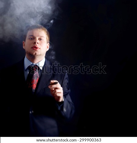 The man in costume smoke a cigar, looks at us. lots of smoke. A dark background