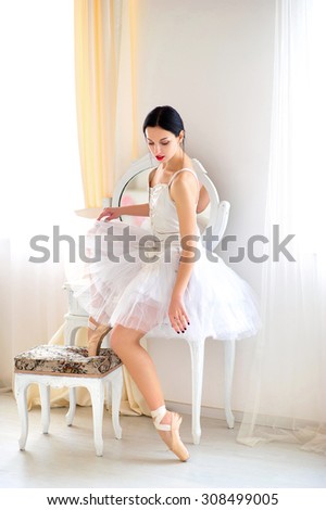 Beauty brunette ballerina in interior, wearing ballet skirt and corset.