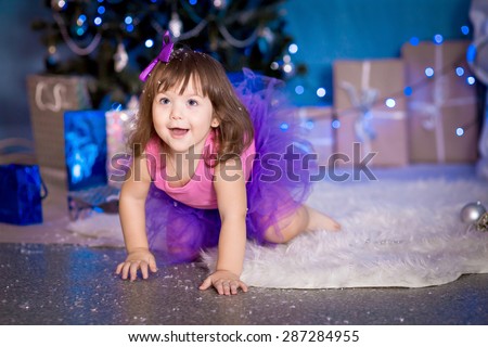 little girl in a tutu skirt in the New Year interior crawling and laughing