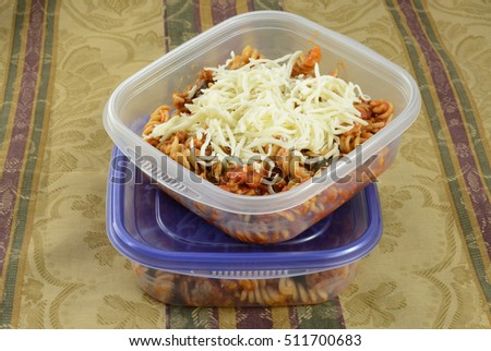 Putting casserole leftovers into plastic containers for work lunches or for freezing with shredded cheese as extra ストックフォト © 
