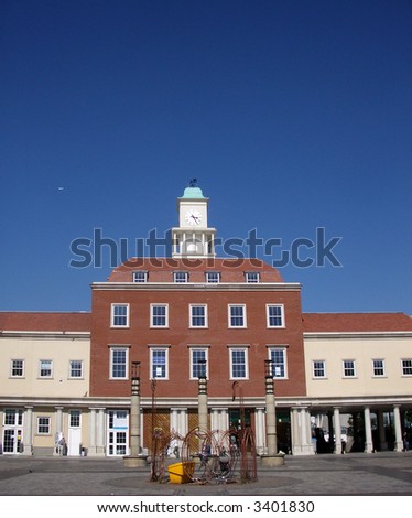 A photograph of new but more traditional styled office building, in Romford market. You can see a clocktower on top of the building.
