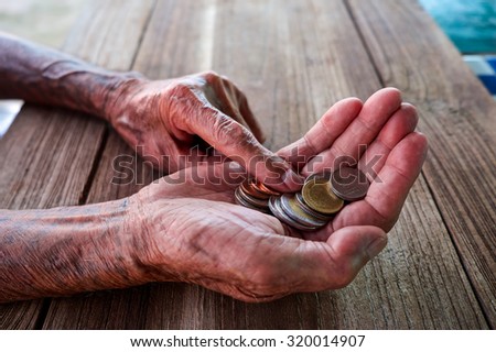 Hand the old man and pile coin for saving. money saving concept.